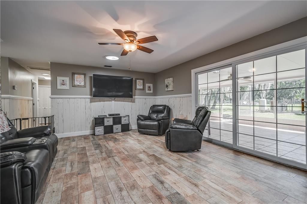 Family Room with Crown Molding, Wall Molding & Trim throughout Pecky Cypress Wainscoting (Wall Panels). New Wood Plank Ceramic Tile throughout entire main house. New Ceiling Fans and Light Fixtures throughout. Double Pane Sliding Glass Door