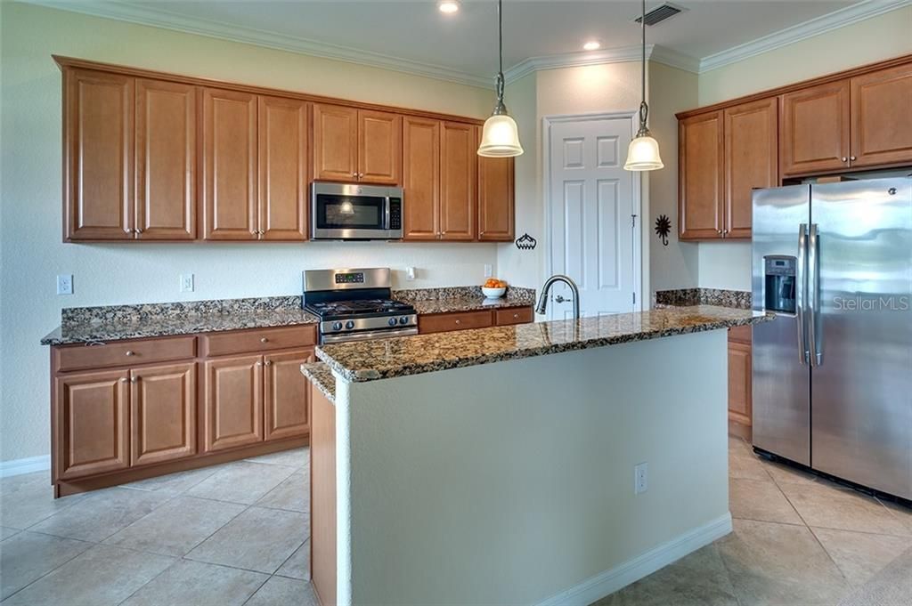Expansive Gourmet Kitchen Features Breakfast Bar, Pendant Lighting and Closet Pantry