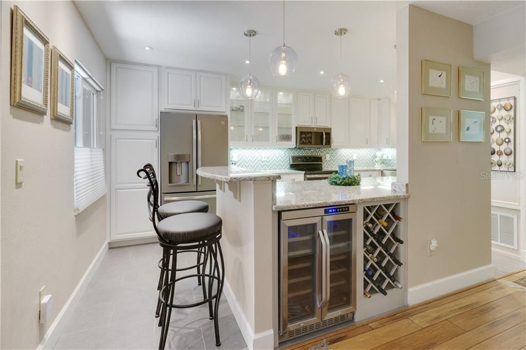 BREAKFAST BAR AND ISLAND WITH WINE REFRIGERATOR AND BUILT-IN WINE RACK