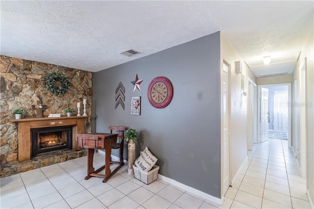 9606 N. Hartts Drive, Tampa, FL 33617 - Wood burning fireplace and view of hallway to bedrooms.