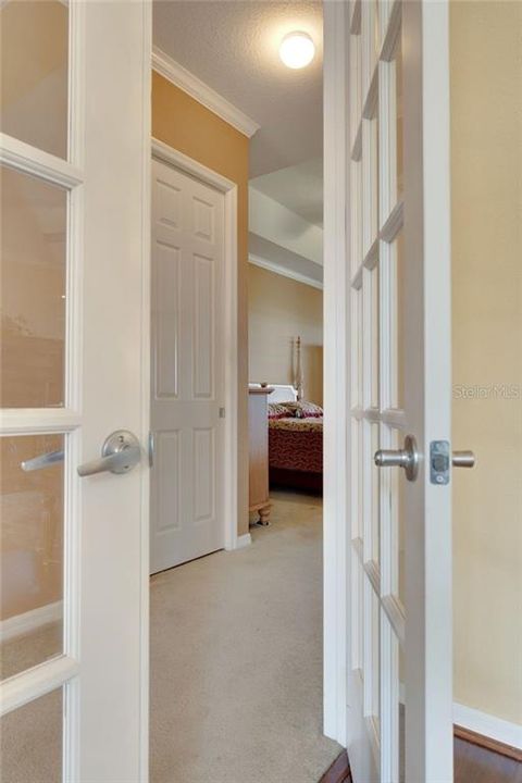 French doors with glass inserts lead in to the master bedroom.