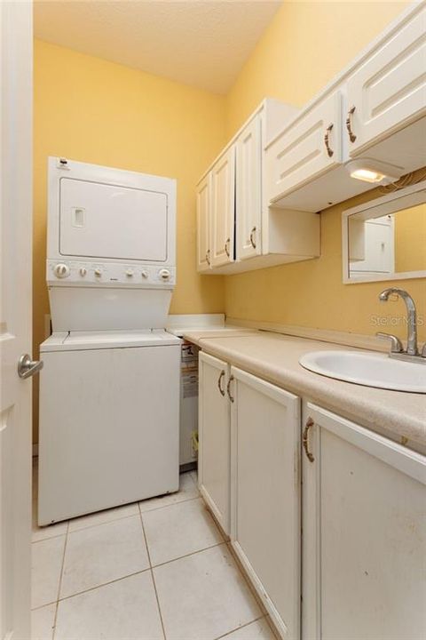 Laundry with cabinets and sink. Stackable washer/dryer does convey with the sale of the home.