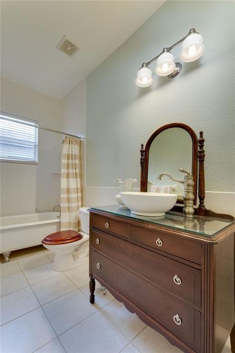 2nd bathroom complete with antique vanity and claw foot tub.