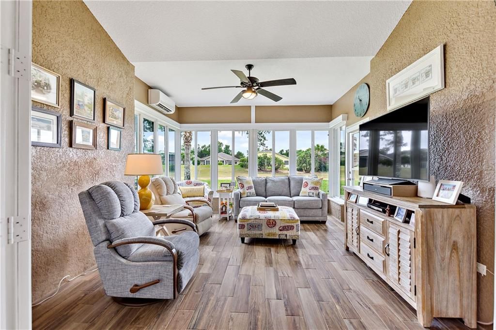 Florida room overlooking the boulevard. Level entry from living room through full-view French doors. Porcelain tile flooring, Low-E glass windows with privacy sunshades. Cabana door access to under-roof screened lanai.