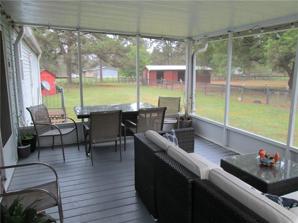 Covered and screened porch with view towards barn