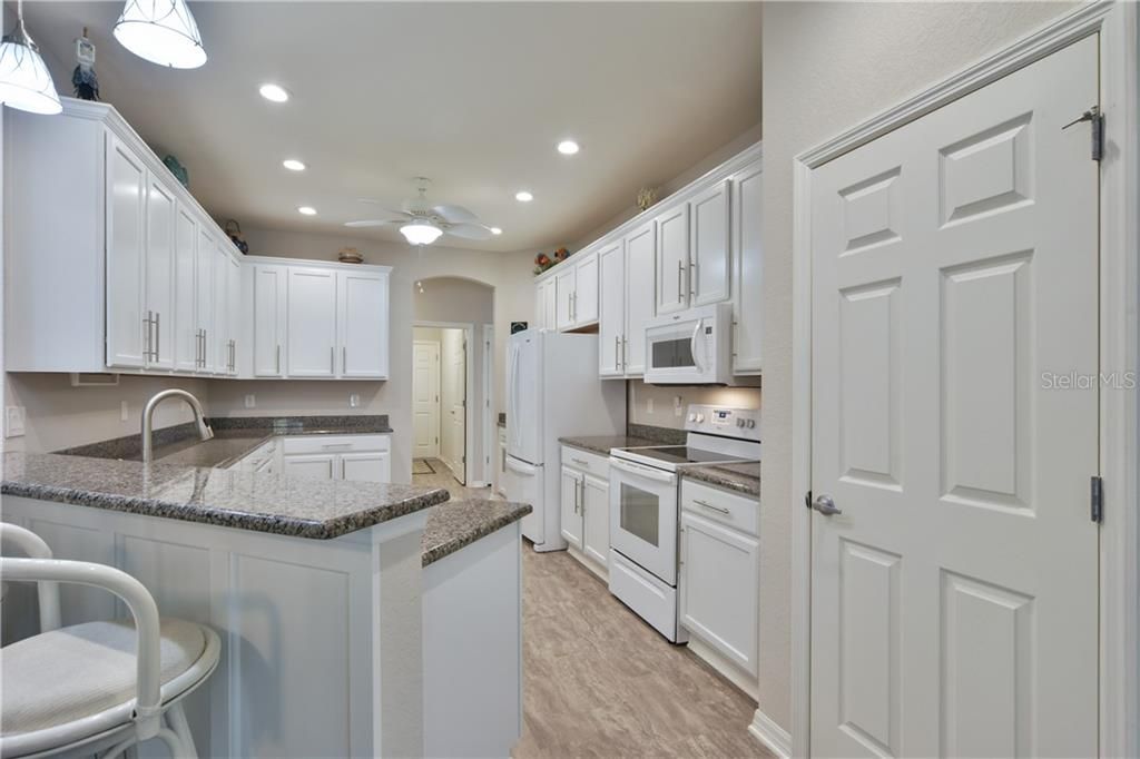 White cabinets, beautiful satin nickel hardware, granite counters, vinyl flooring that's continued through the entire family room and a nice pantry.