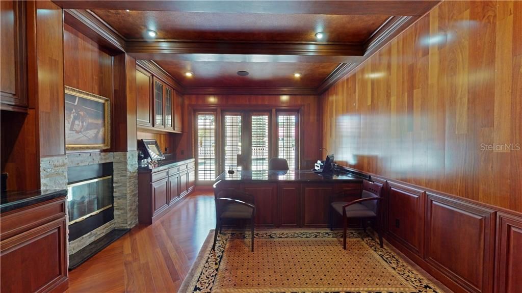 First floor den/study with coffered ceiling, gas fireplace, built-in bookcases and numerous custom wood details.
