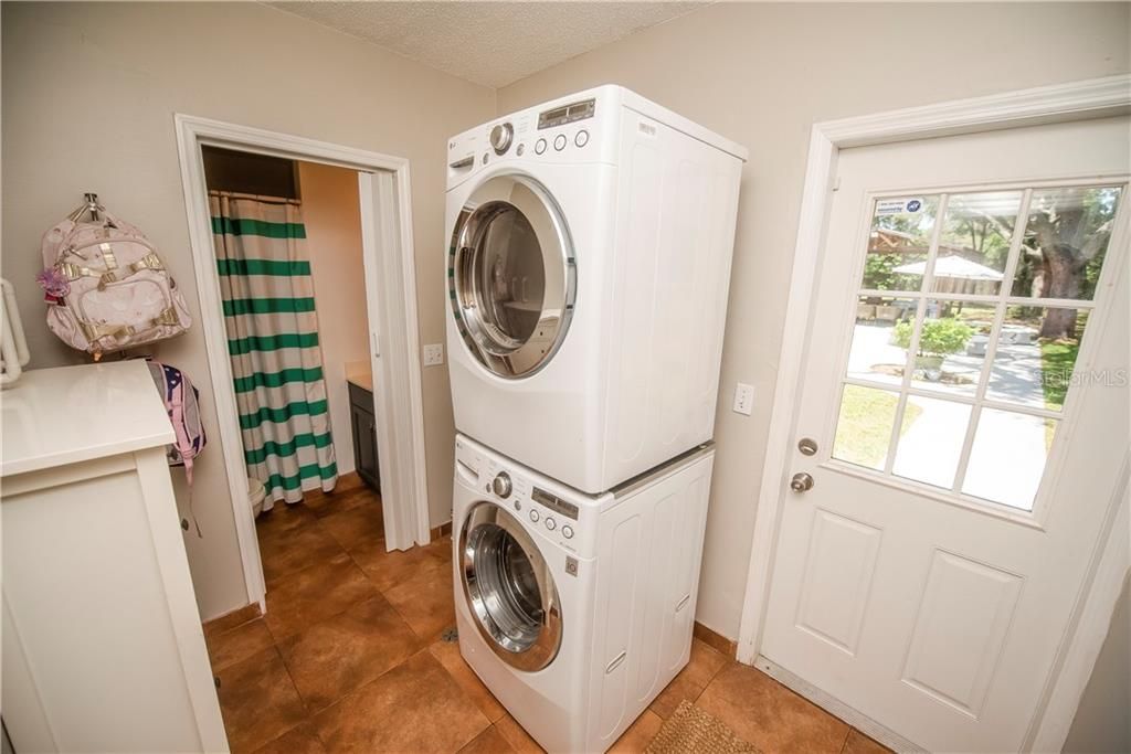 Back downstairs, the laundry is conveniently located by pool area and off the kitchen.  There is a space for a drop zone off the garage too.