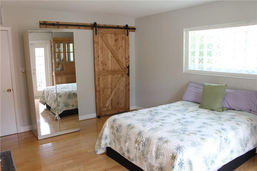 Master bedroom with a private bathroom through the barn door.