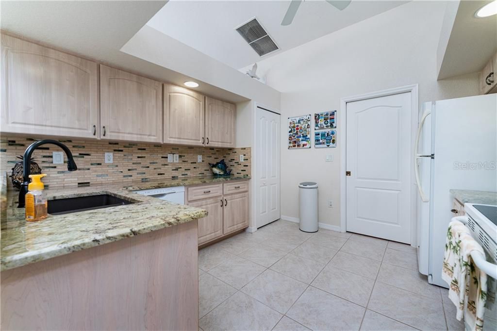At the heart of this charming home is the kitchen, complete with granite countertops, a nicely coordinated backsplash, and a pantry closet.
