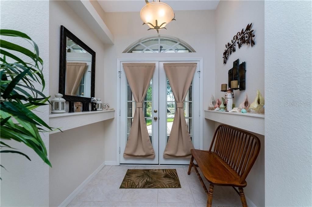 A double front door with a transom allows abundant natural light to grace the foyer.
