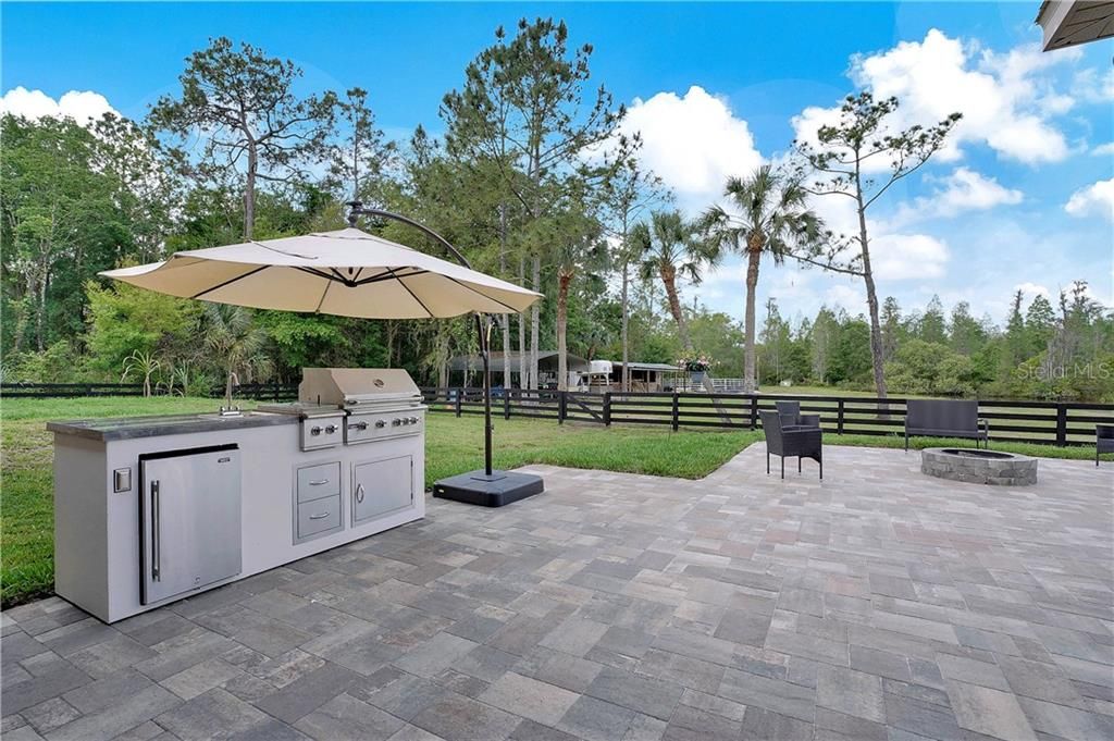 Brand new out door kitchen.  New grill with rotisserie, sink with water and working fridge.  This outdoor kitchen has all the bells and whistles.  New sod around the pavers