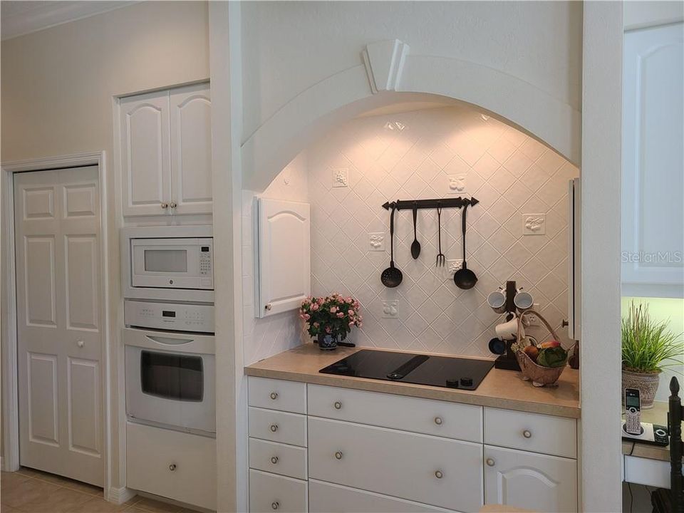 This area was designed by the seller - Jenn Air cooktop with built in spice racks.  Jenn Air oven and large pantry