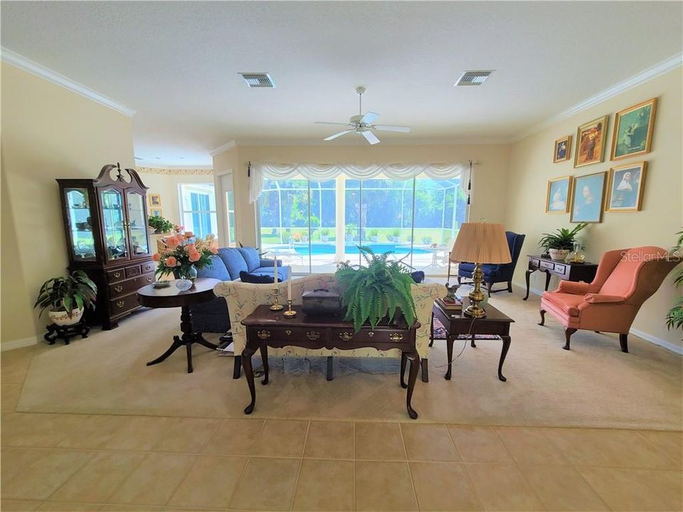 Open, well lit Living room over looking pool - Four sliding doors to patio