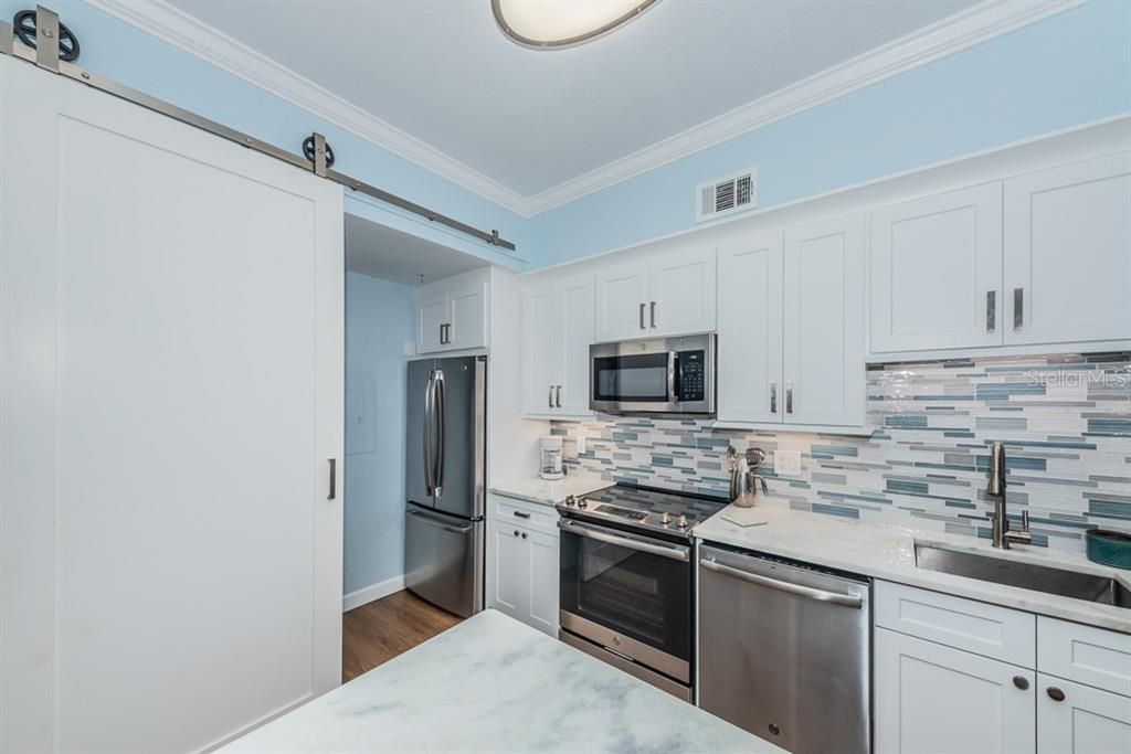 Kitchen with a "barn door" to the laundry area