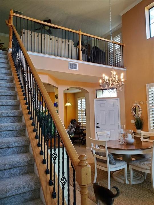 CUSTOM UPGRADE STAIR RAILS WITH WROUGHT IRONWORK. VIEW LOOKS UP INTO LOFT AND INTO DINETTE IN KITCHEN