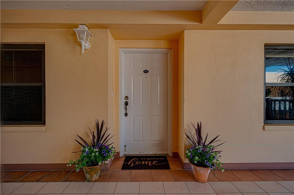 Tile Entry, large front porch with tropical plants throughout.