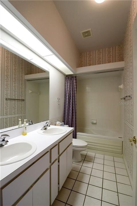 GUEST BATH ALSO HAS A DUAL SINK VANITY AND TUB WITH SHOWER