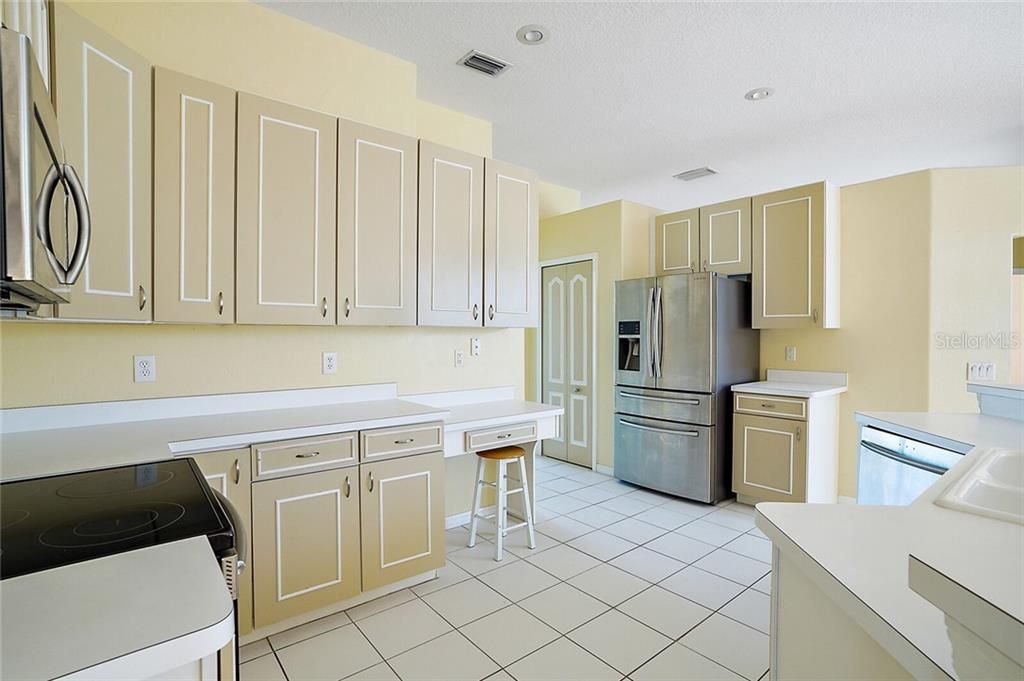 Spacious Kitchen with ample counters, cabinets, a built-in desk and closet pantry.