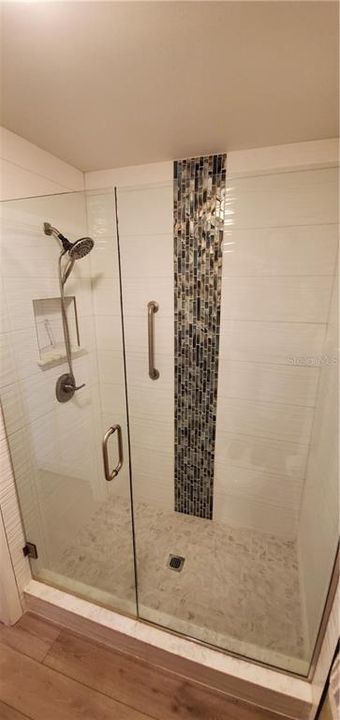SHOWER WAS DESIGNED WITH BEAUTIFUL WHITE TEXTURED TILE AND A FEATURE