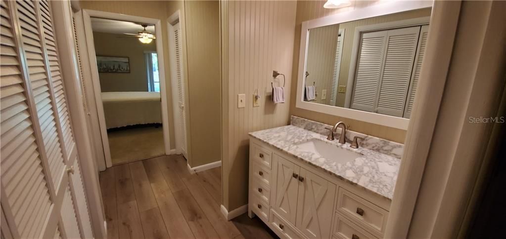 VIEW FROM DRESSING AREA AND VANITY TOWARDS THE MATER BEDROOM  HAS A POCKET DOOR