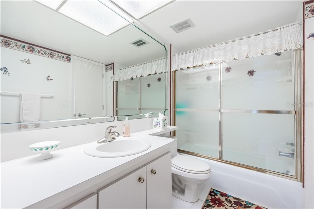 Bathroom with tub and sliding glass doors