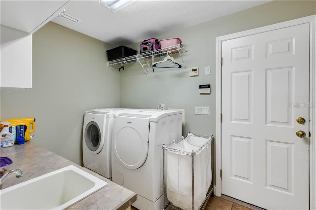 Laundry Room offers a Utility Sink, Bosch Washer & Dryer and Additional Cabinetry
