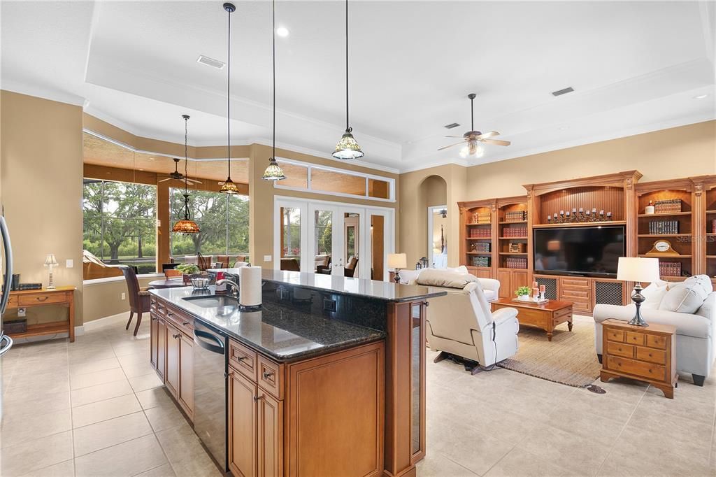 Kitchen features spacious granite breakfast bar with pendant lights.