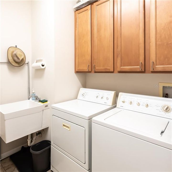 Laundry room has a sink, full size washer & dryer & 42" Maple cabinets!