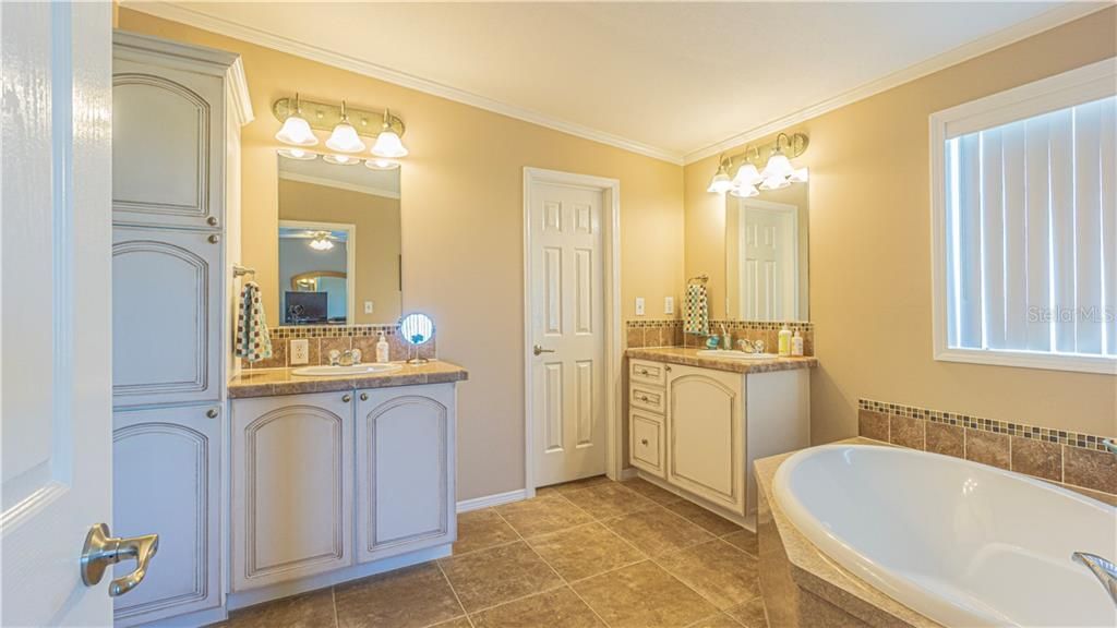 Master bathroom with garden tub and dual sinks. Large walk in closet is located between sinks.