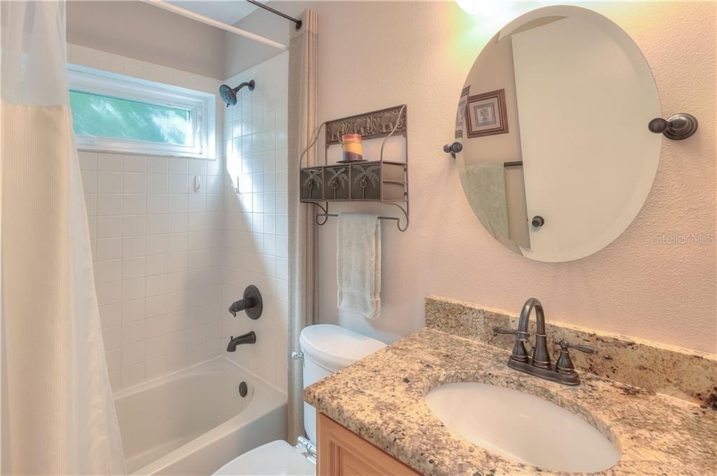 Update guest bath offers GRANITE counters, upgraded mirror, lights & fixtures, comfort height commode & a tub/shower combo.