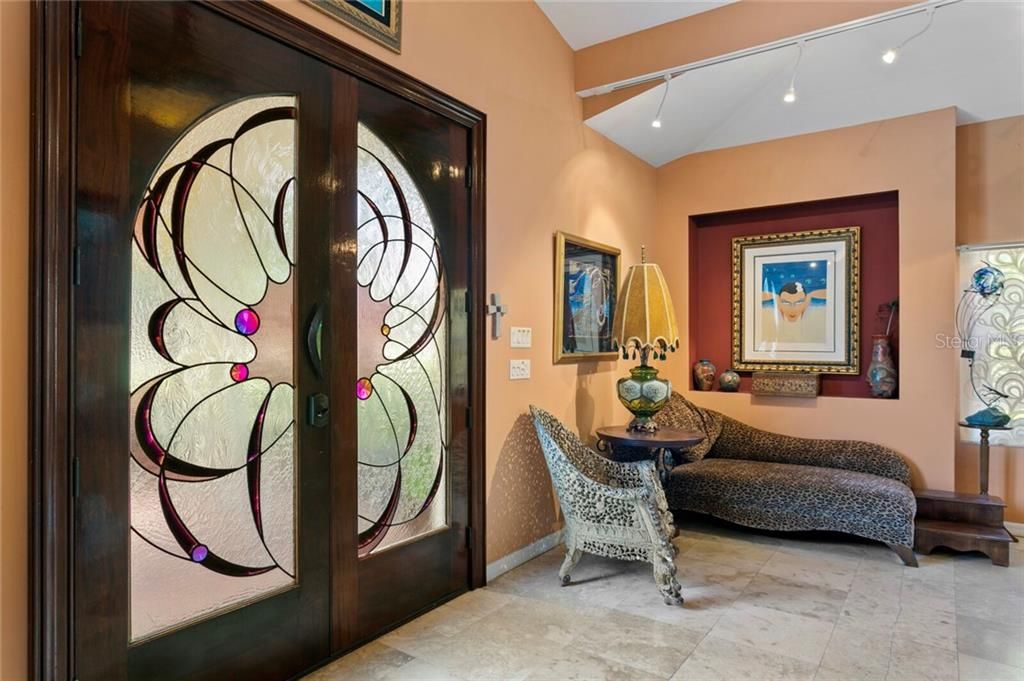 Custom wood & stained glass double door entry into the foyer