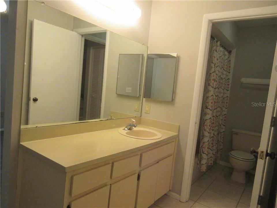 Private vanity area with shared bathing room