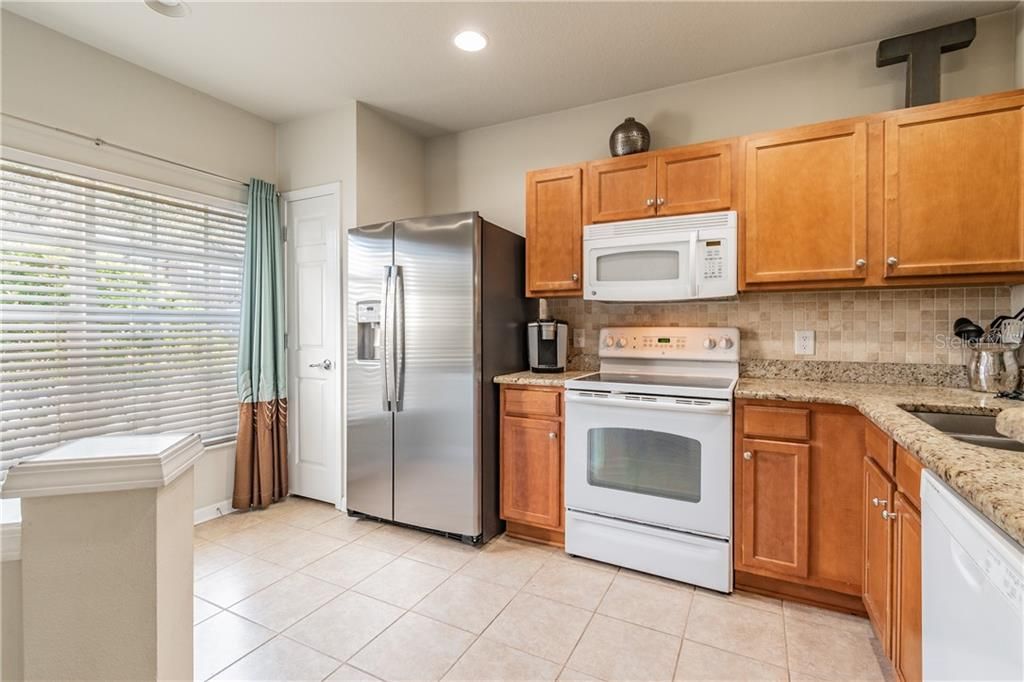 Newer refrigerator, wood cabinets and granite countertops.