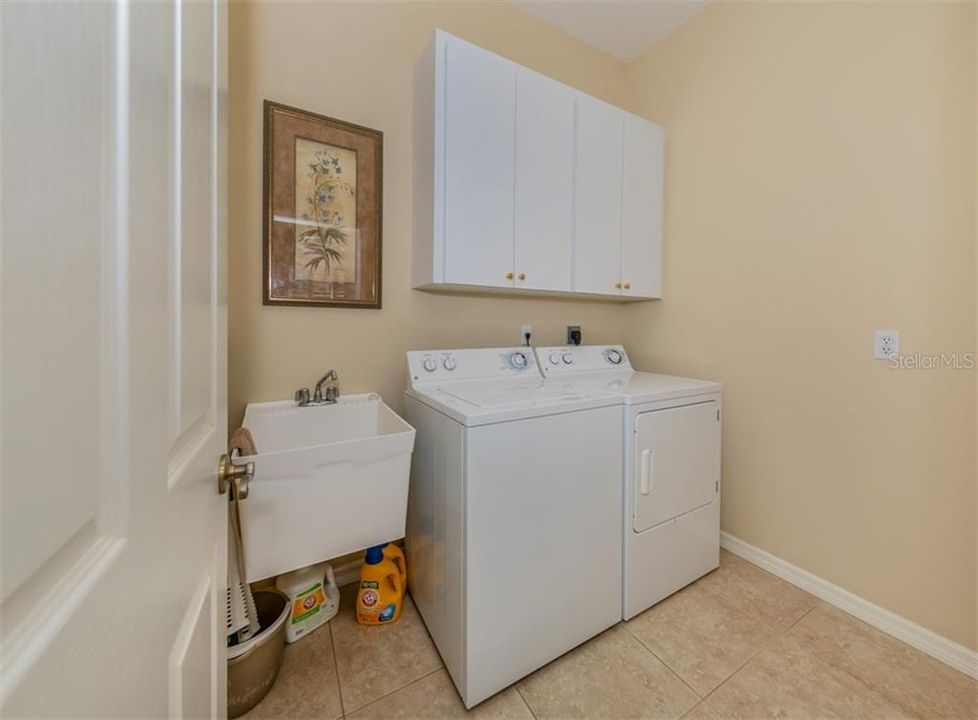 Laundry room with utility sink and cabinets for storage.