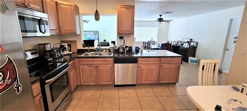 Real wood cabinets with stainless steel appliances. Open to the living room and dining room.