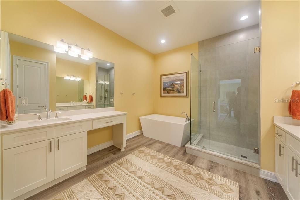 Master Bath features dual oversized vanities, shower with frameless glass enclosure, tile to ceiling, delightful soaking tub (always filled with hot water from the natural gas tankless hot water heater).