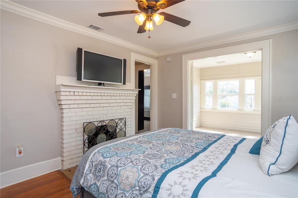 Upstairs master bedroom with wood burning fireplace and sun room with great natural light