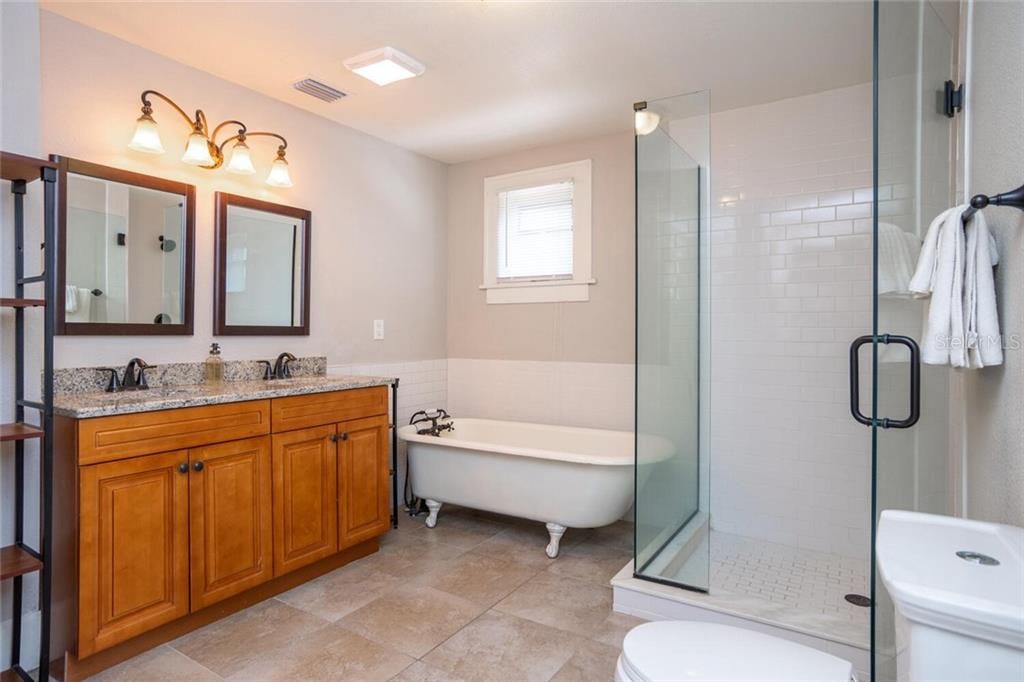 Spacious master bath with glass enclosed shower stall, dual vanity and stand alone tub