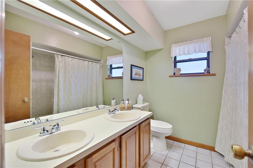 Guest bath has dual sinks and a tub/shower combo.