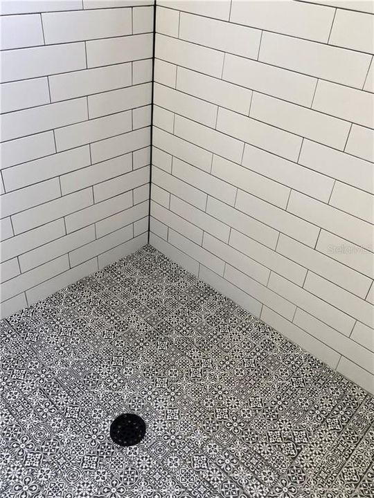 Classic black and white colors with subway tile and gorgeous shower floor.