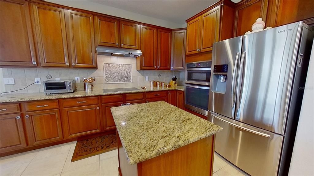 This kitchen has plenty of wood cabinets and granite countertops