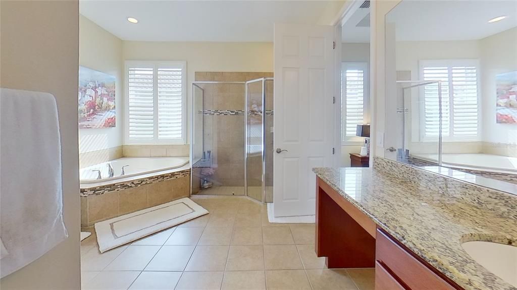 The master bathroom is spacious and full of muted natural light.