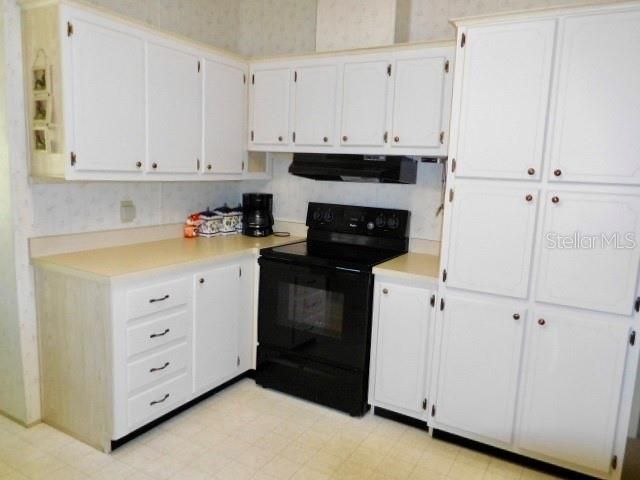 ANOTHER VIEW OF KITCHEN WITH MANY CABINETS FOR STORAGE.