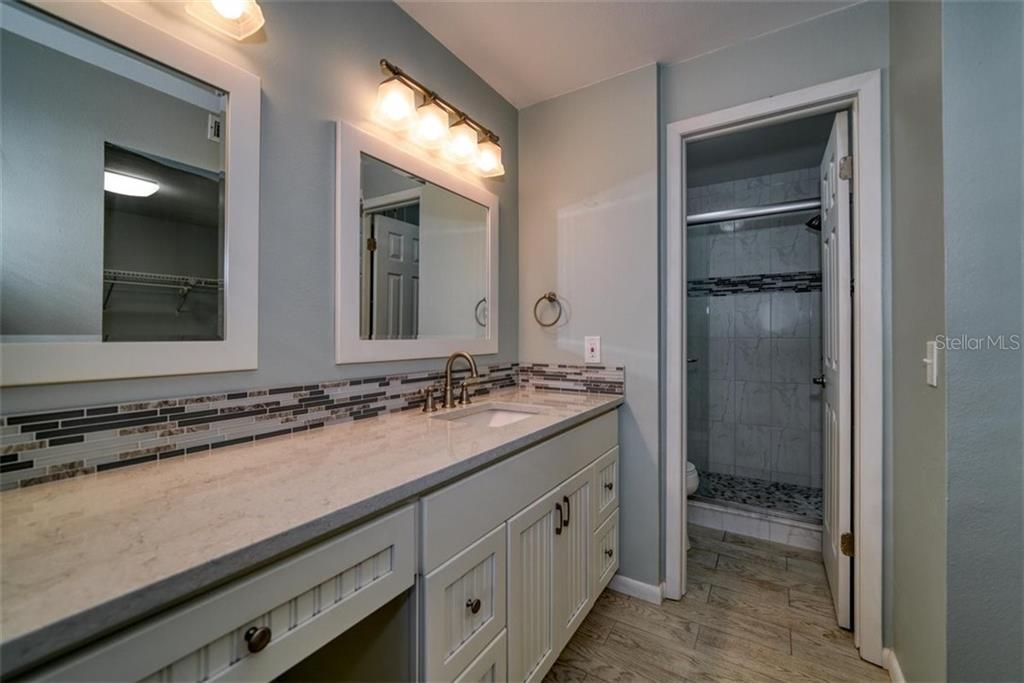 Gorgeous updates in this Master Bath with Stone Counters and updated shower