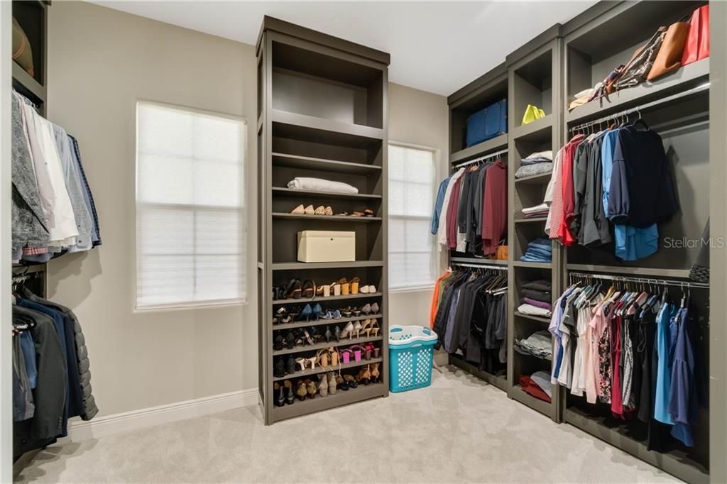 This master closet is large, with custom built wood units