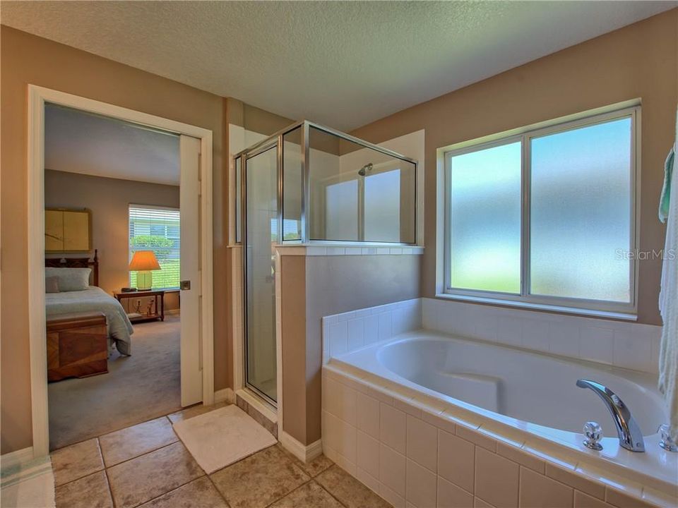 Garden tub, frosted opening window, and step-in ceramic tiled and glass shower!
