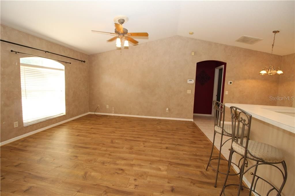 Living room with newer laminate wood flooring.  Vaulted ceilings...