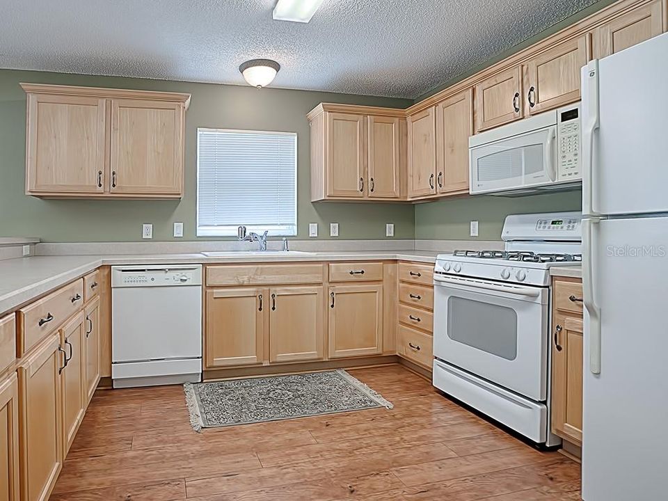 SPACIOUS KITCHEN WITH HONEY MAPLE CABINETS WITH CROWN MOLDING.