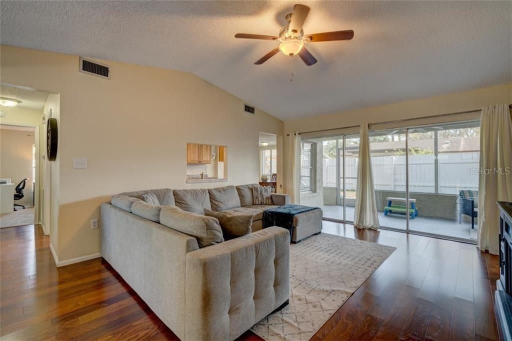 As you enter the home, you'll find a bright and spacious living room with large sliders out to the screened porch